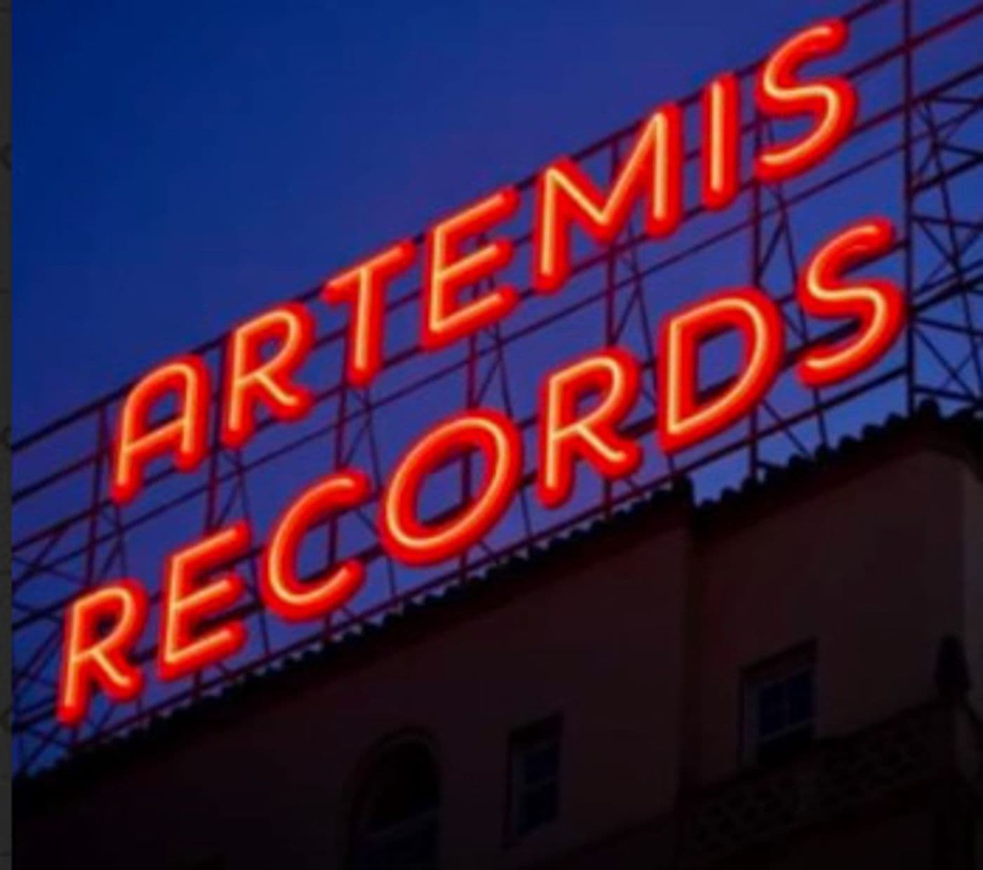 The Artemis Records neon rooftop sign glowing red against a blue evening sky